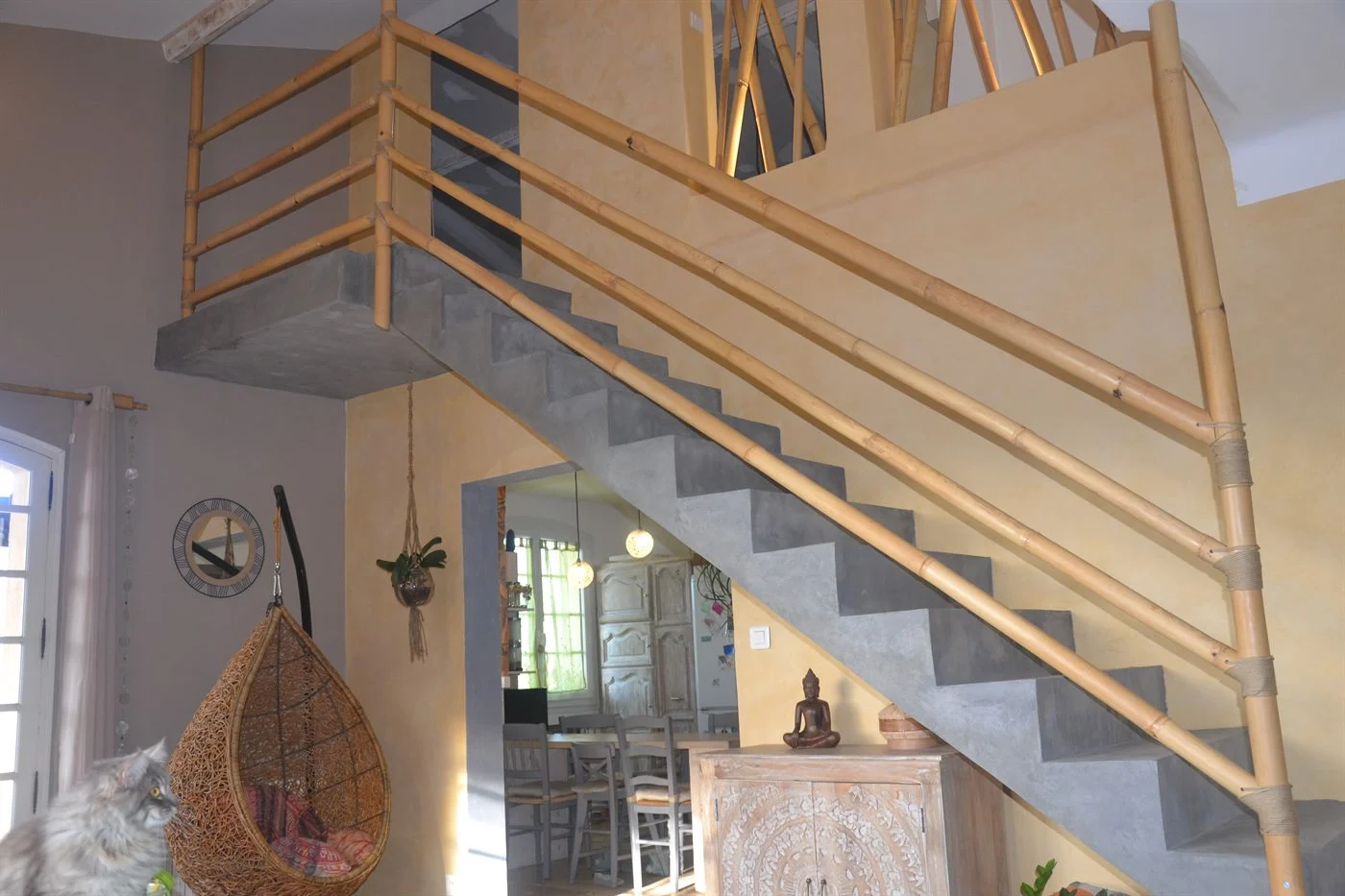 Rambarde en bambou à tronçons parallèles le long d'un escalier en béton, jusqu'à la mezzanine