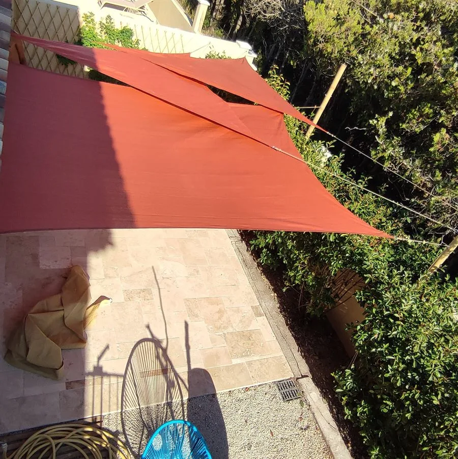 Voile d'ombrage tendue sur des mâts en bambou